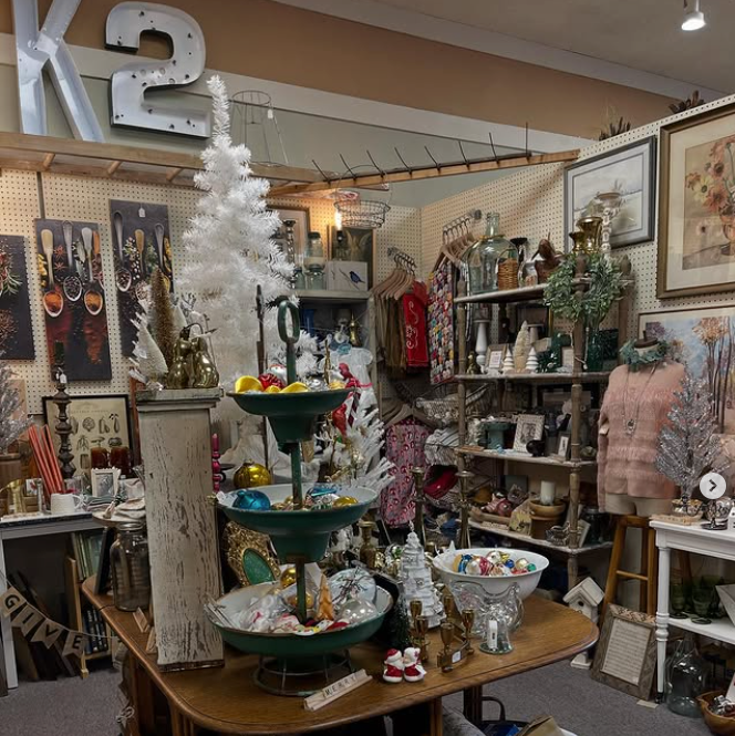 Antique store interior with various items on display: Christmas decorations, artwork, and furniture.