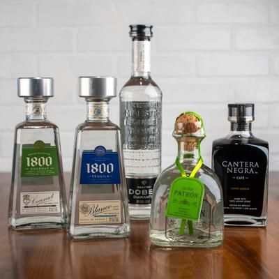 Five tequila bottles: 1800 Cristal, 1800 Blanco, Dobel Diamante, Patron, and Cantera Negra. 