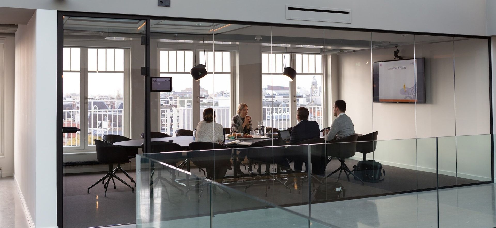 A group of people are sitting around a table in a conference room.