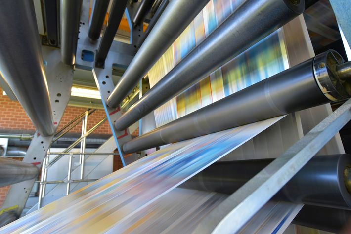 A printing machine is printing newspapers in a factory