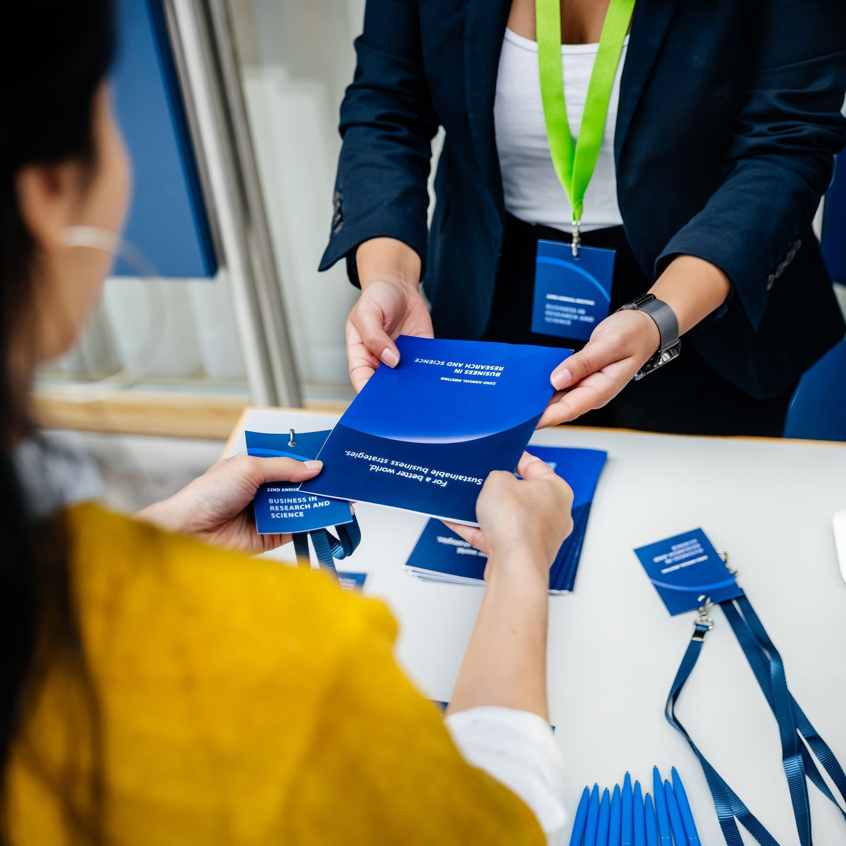 A woman in a blue jacket is holding a blue envelope