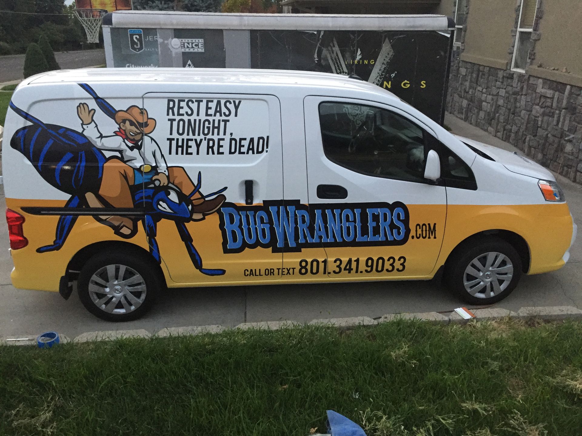 A bug wranglers van is parked in a driveway A bug wranglers van is parked in a driveway