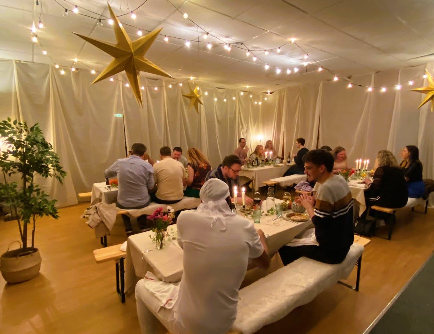 A group of young adults enjoying a meal at a feast night