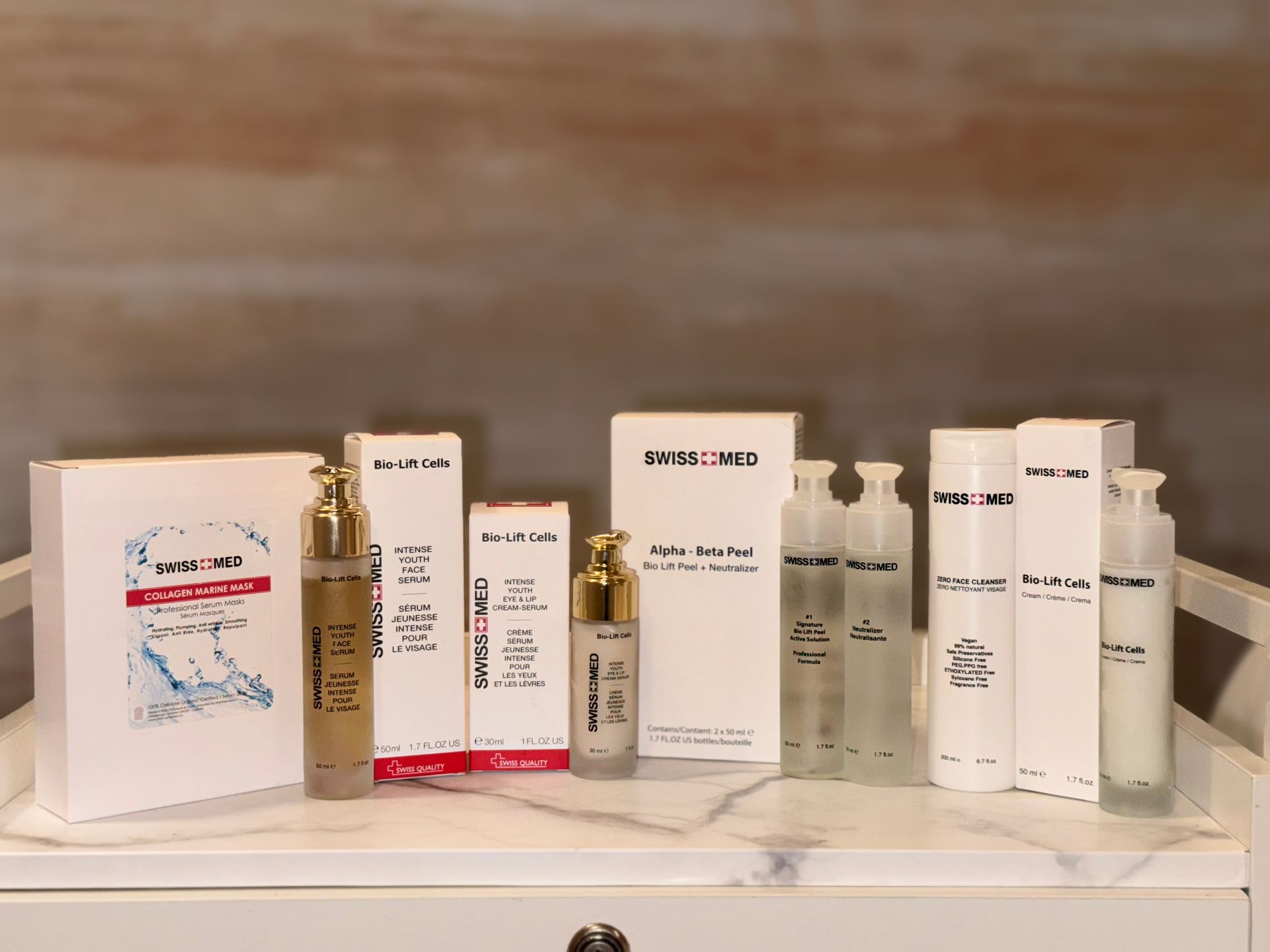 Skincare products on a white surface against a neutral background. Various white boxes and bottles are arranged neatly.
