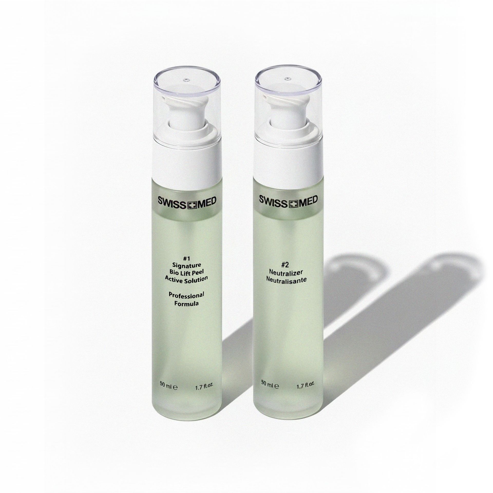 Two clear bottles of Swissmed3 skin care products, with white pumps, on a white surface.
