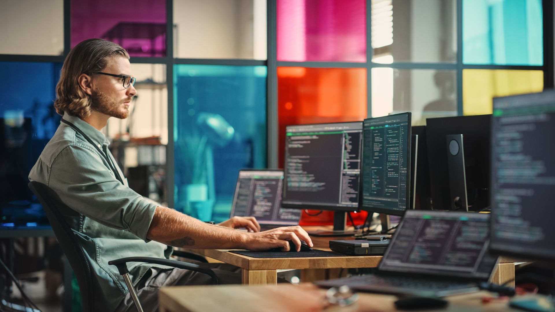 A man is sitting at a desk in front of a computer.