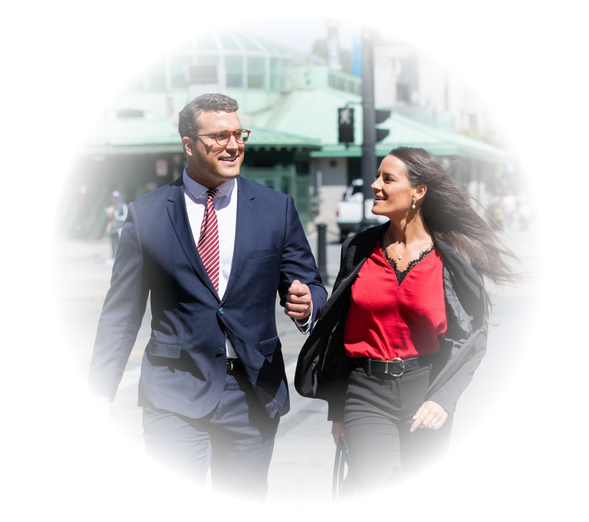 A man in a suit and tie is walking with a woman in a red shirt.