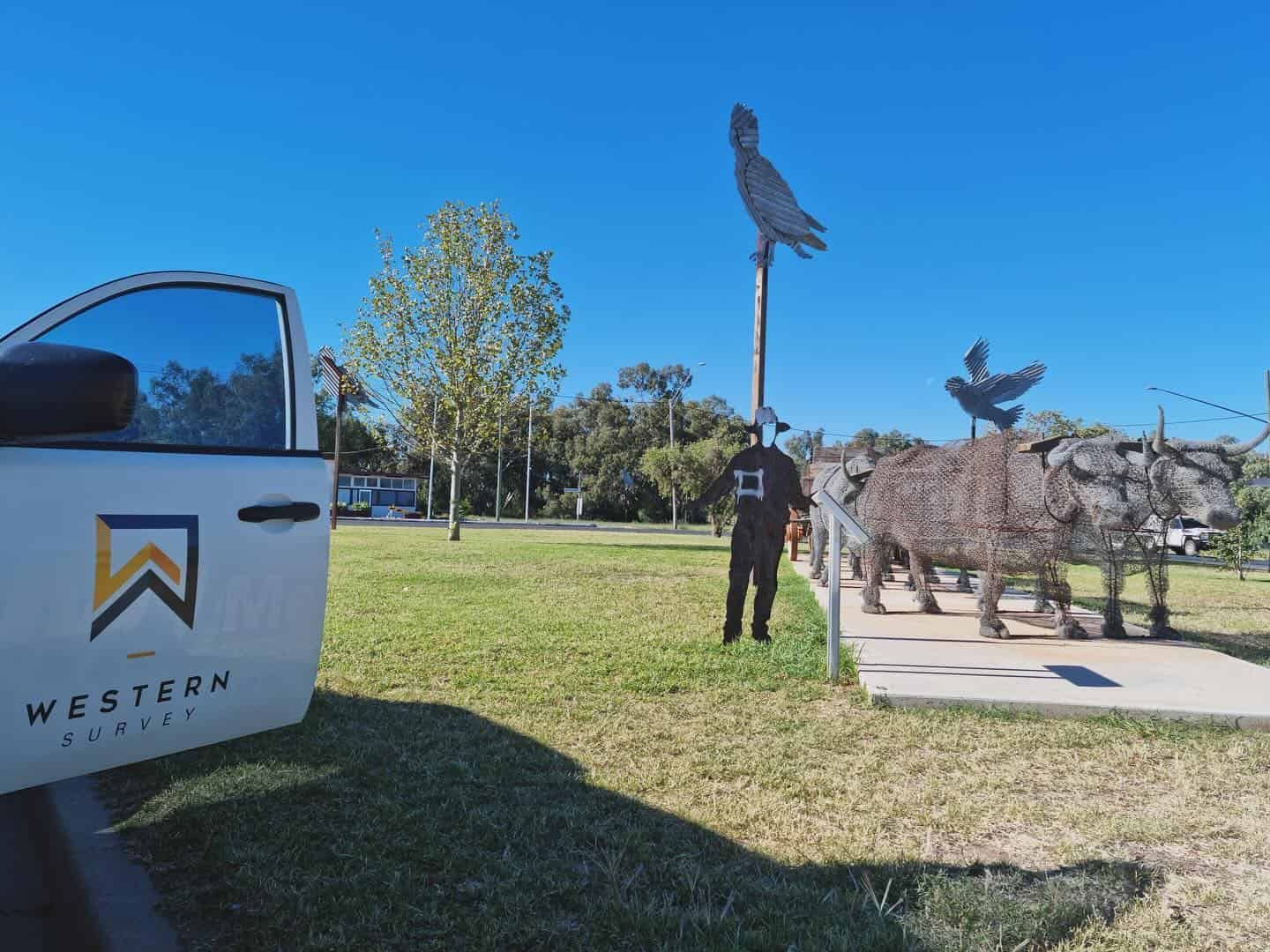 A Man Is Standing Next To A Truck In A Park — Western Survey Pty Ltd In Condobolin, NSW