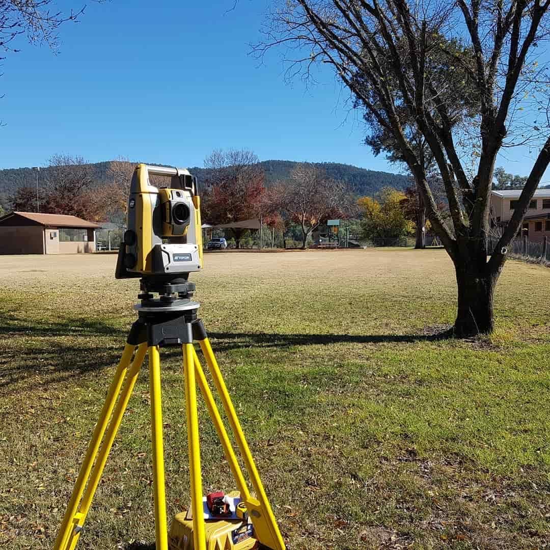 A Yellow Theodolite Is Sitting On A Tripod In A Field — Western Survey Pty Ltd In Mudgee, NSW