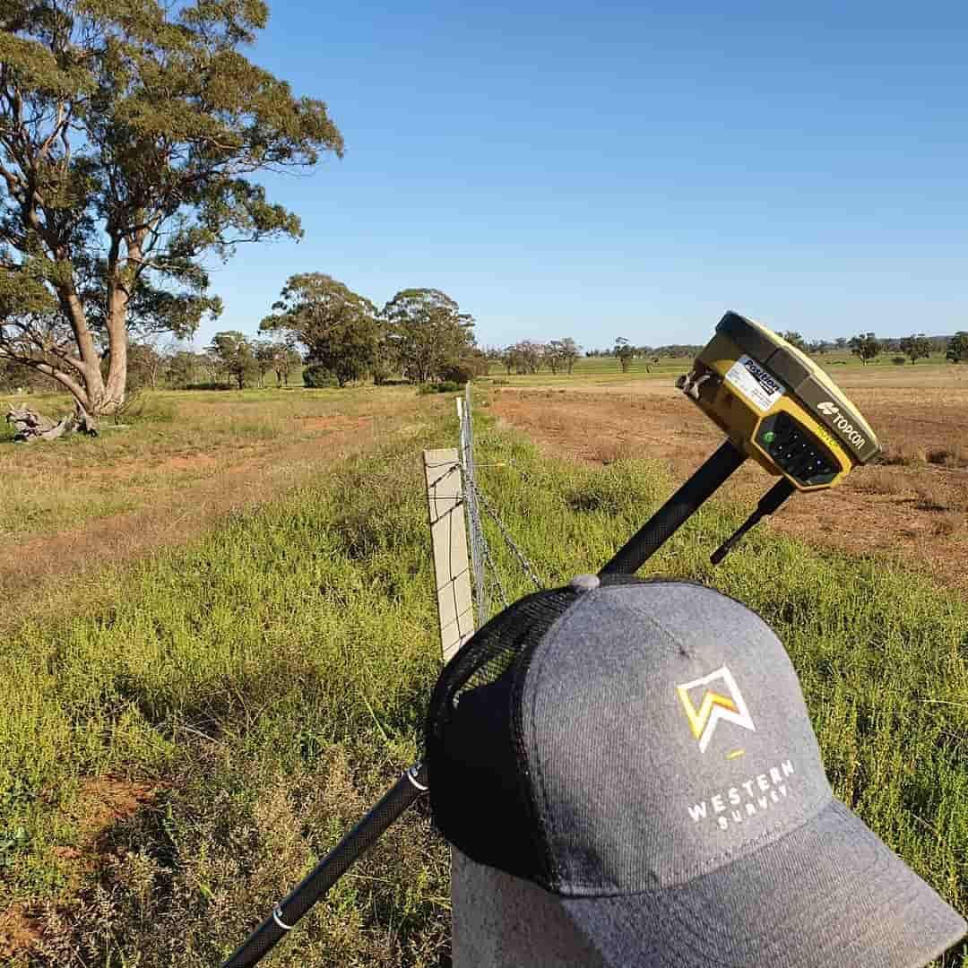 A Person Is Standing In A Field With A Hat And A Device — Western Survey Pty Ltd In Dubbo, NSW