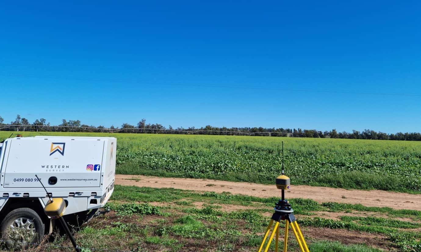 A Tripod Is Sitting In The Middle Of A Field Next To A Trailer — Western Survey Pty Ltd In Dubbo, NSW
