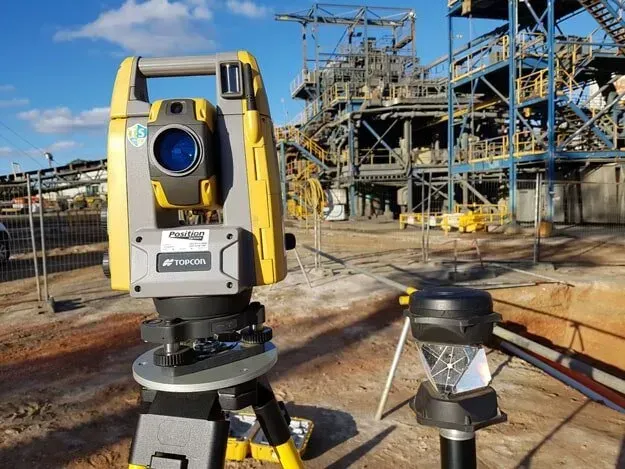 A Yellow And Black Total Station Is Sitting In Front Of A Large Building — Western Survey Pty Ltd In Dubbo, NSW