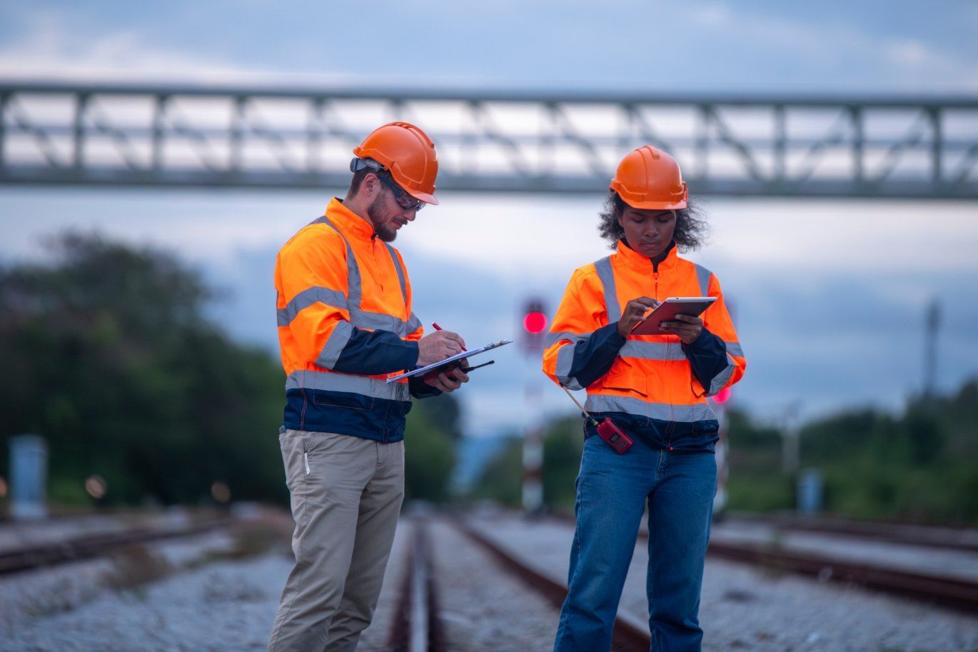 A Man and a Woman Are Standing on Train Tracks Looking at a Tablet — Western Survey Pty Ltd In Dubbo, NSW
