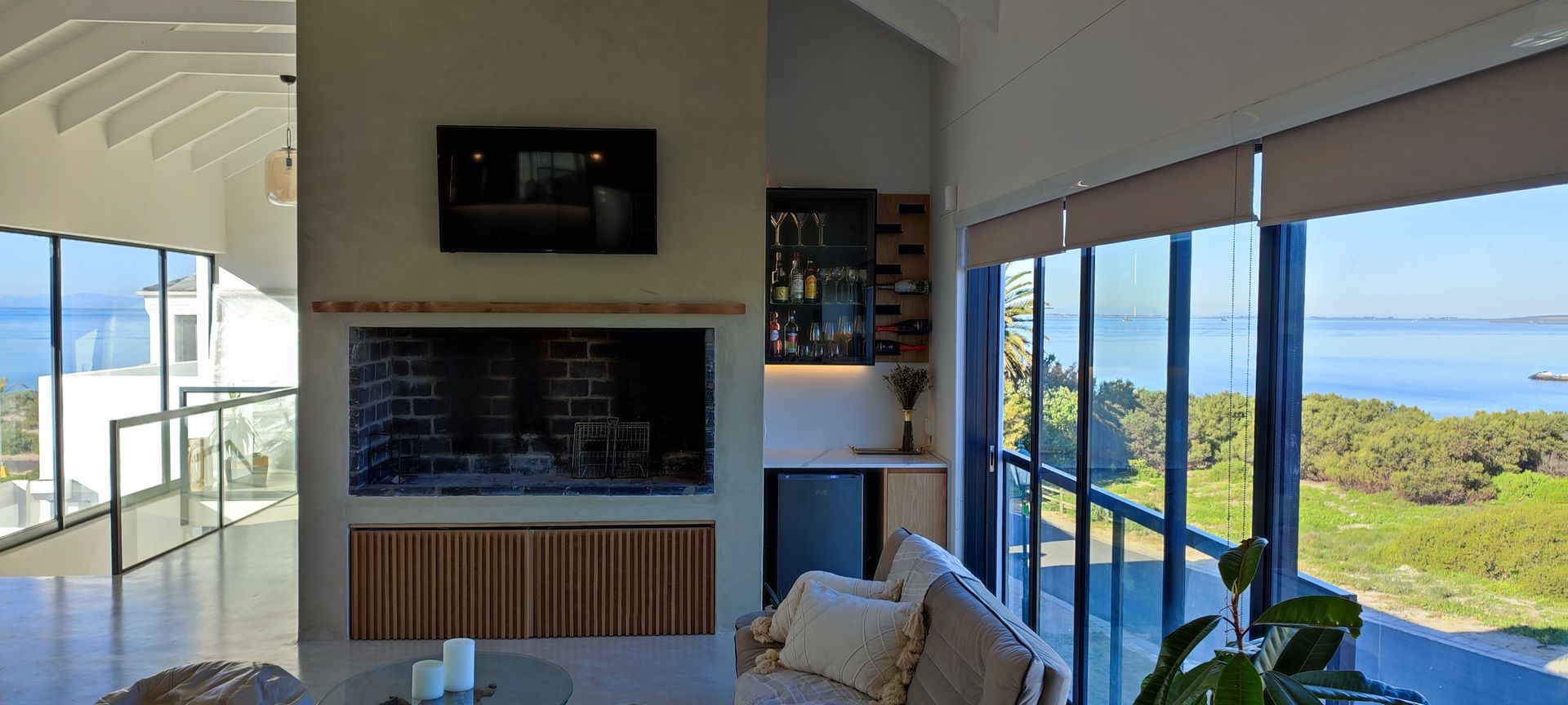 A living room with a fireplace and a view of the ocean.