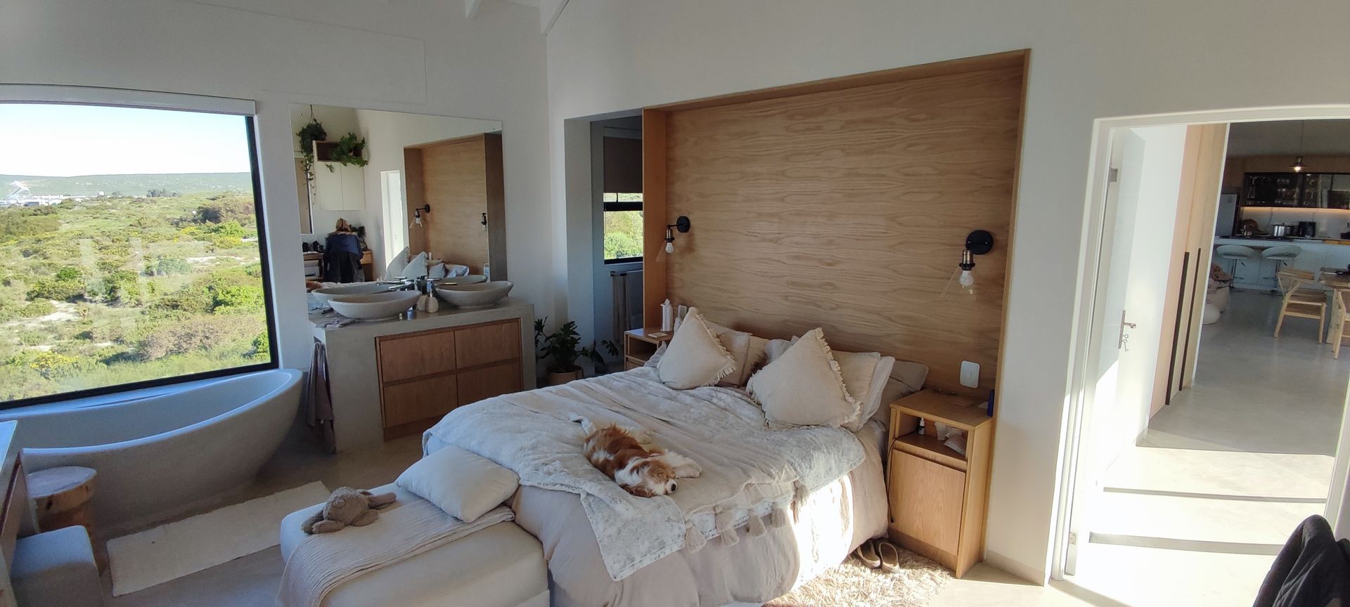 There is a large bed in the middle of the room with a large window.