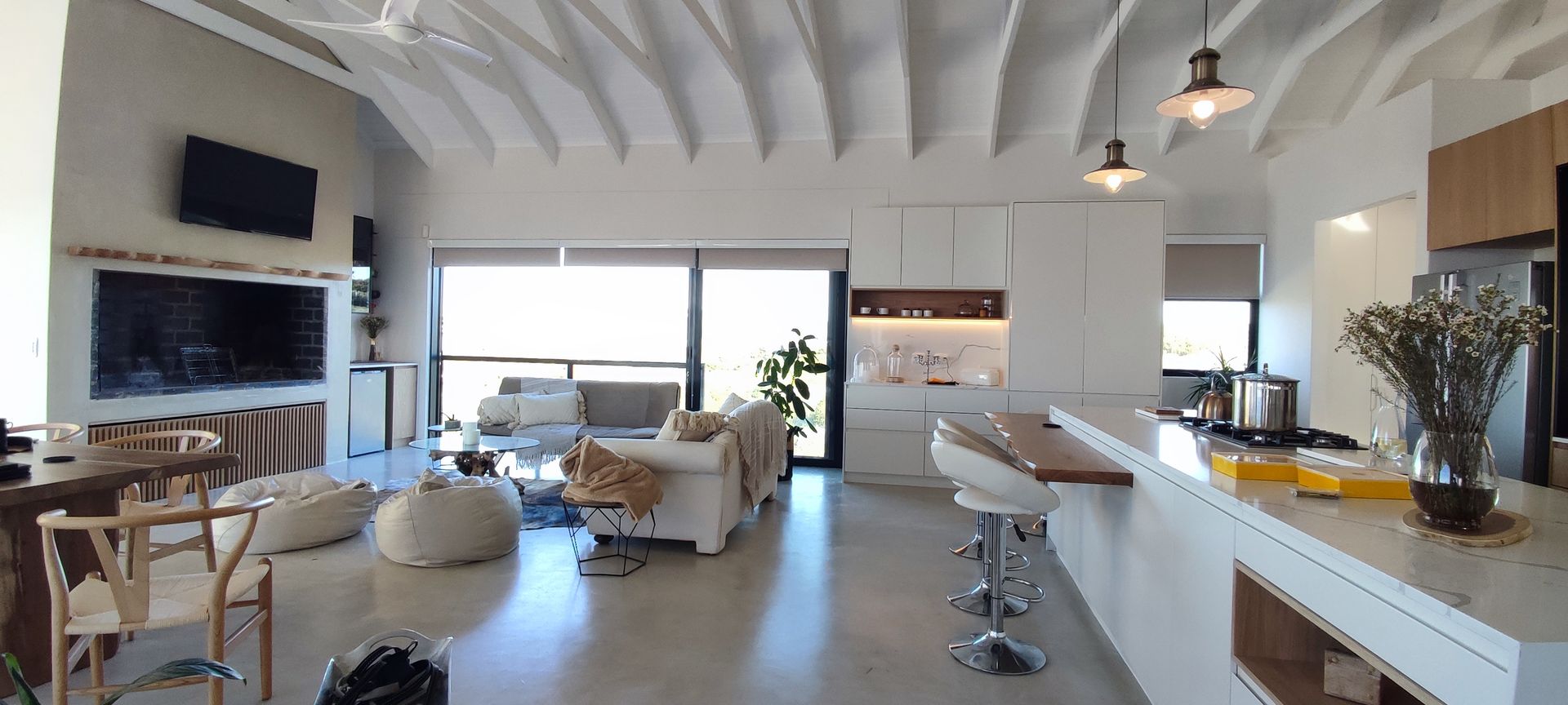 A living room and kitchen in a house with a lot of furniture.