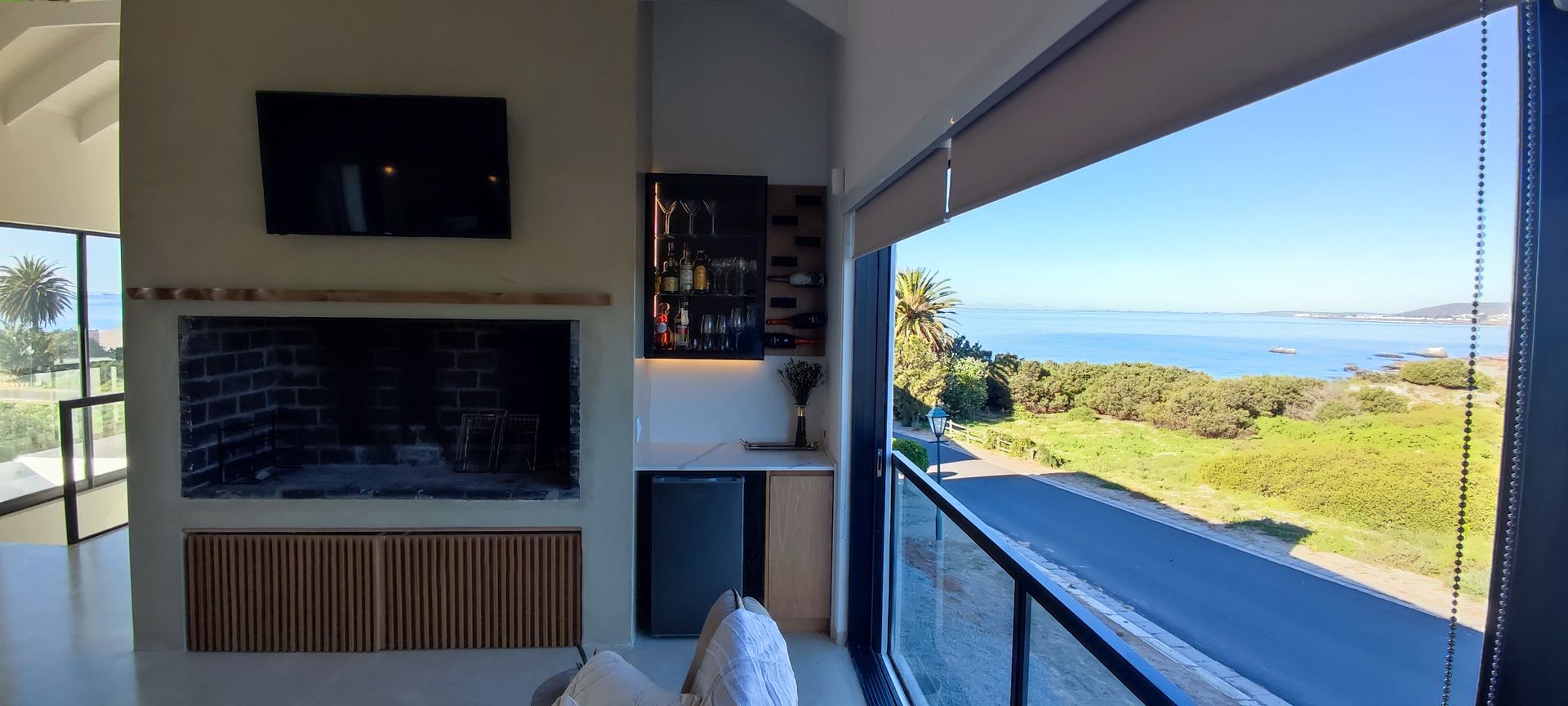 A living room with a fireplace and a view of the ocean.