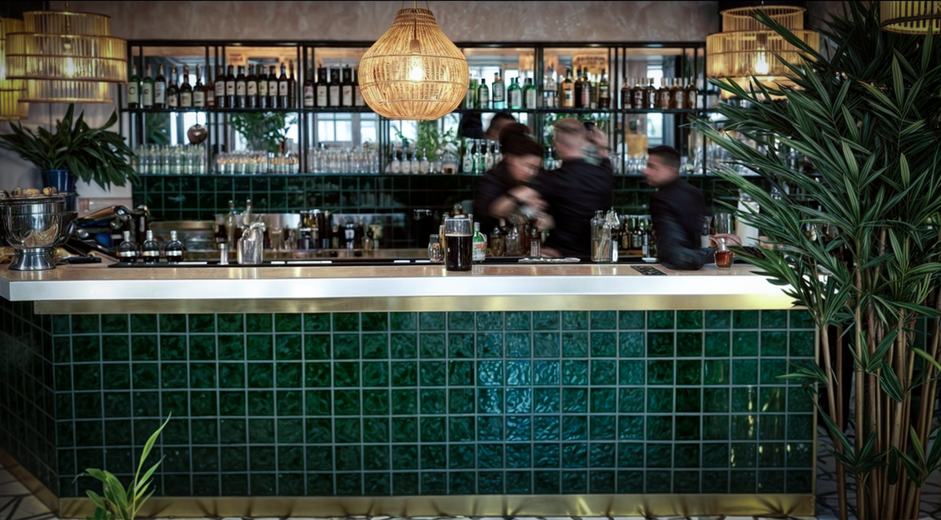 A man is standing behind a bar in a restaurant.