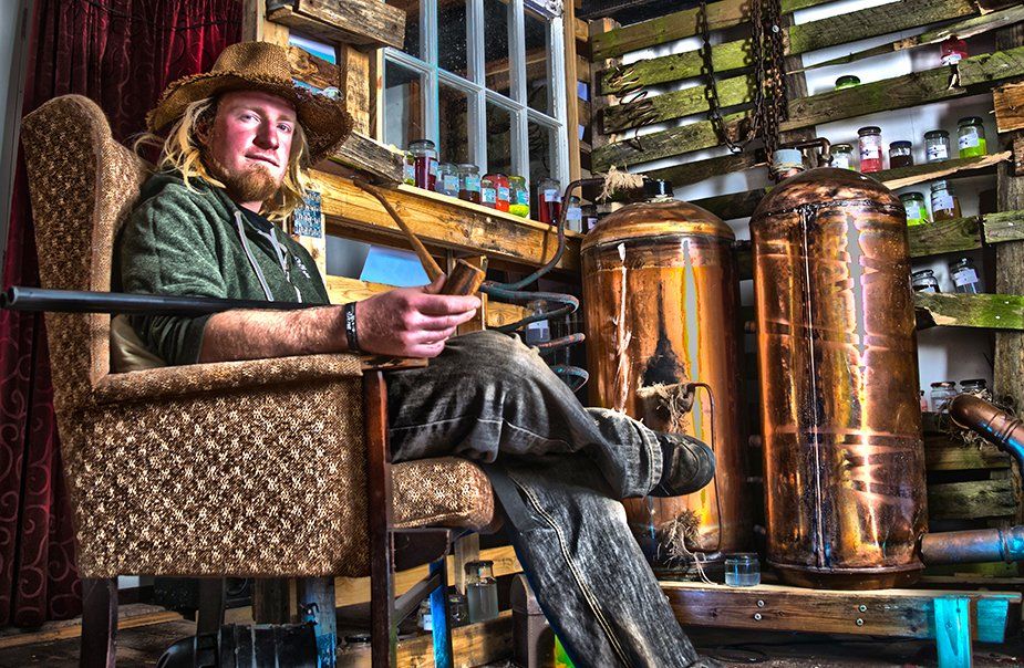 A man is sitting in a chair with a pipe in his hand.