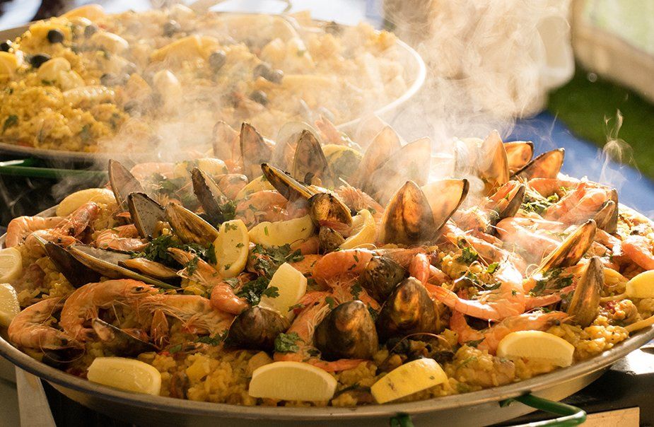 A pan of seafood paella with smoke coming out of it