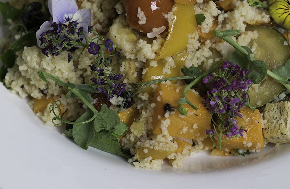 A close up of a plate of food with flowers on it.