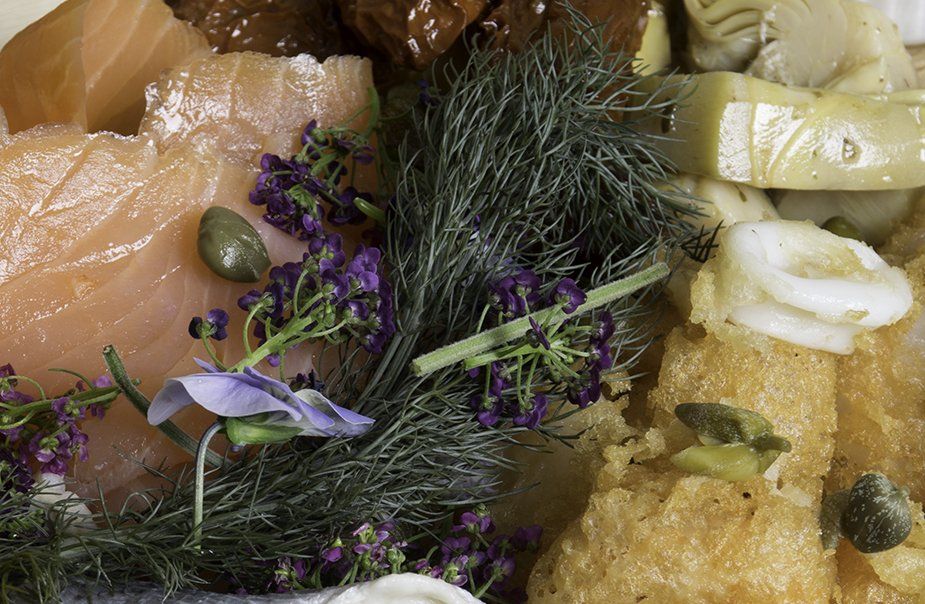 A close up of a plate of food with flowers and vegetables.