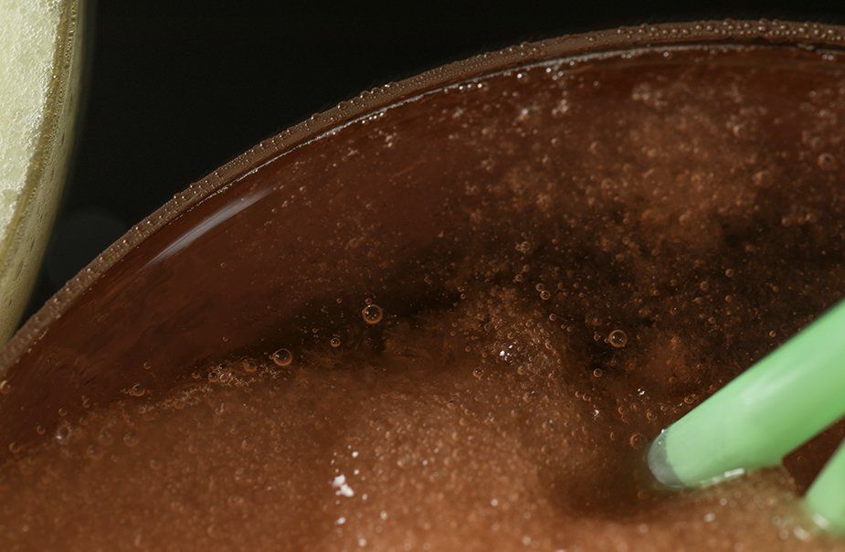 A close up of a bowl of food with a green straw in it.