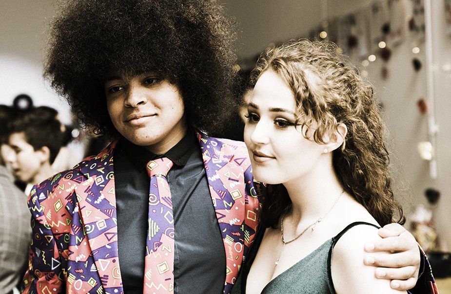 A man with an afro is standing next to a woman