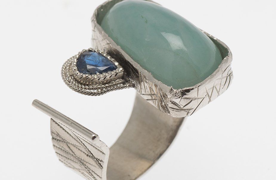 A silver ring with a blue stone on it