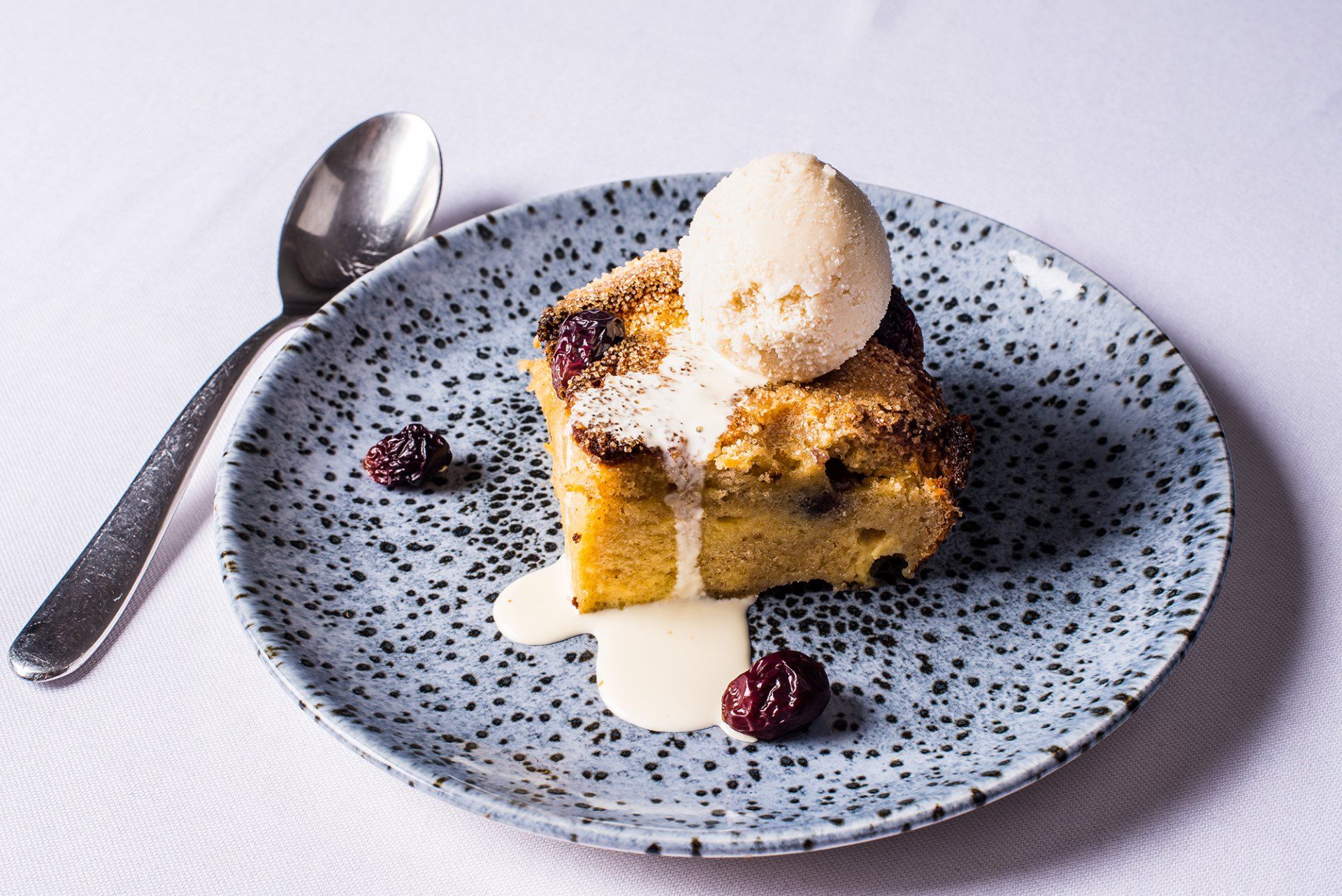 A blue plate topped with a piece of cake and ice cream.