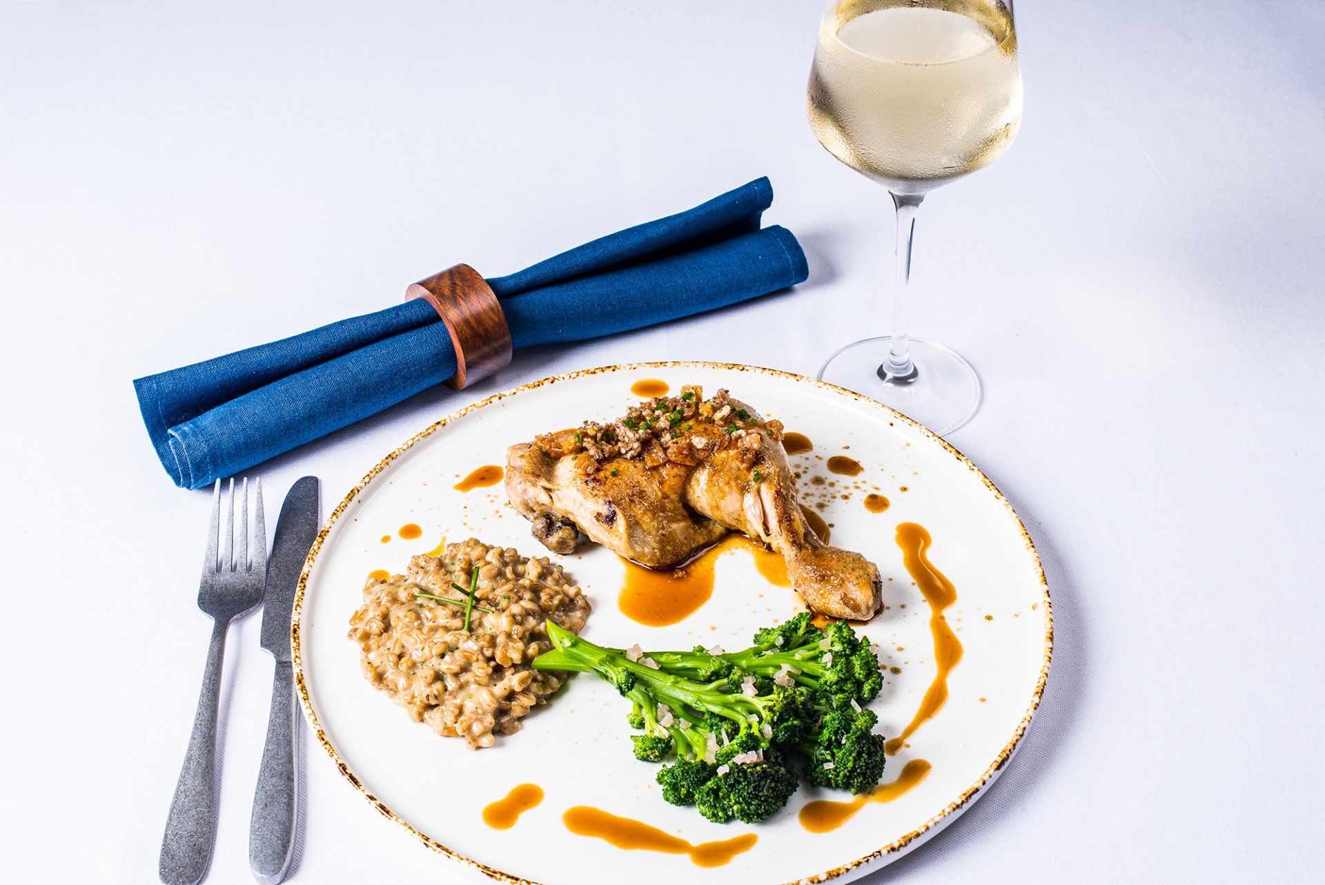 A plate of food with broccoli and rice next to a glass of wine.
