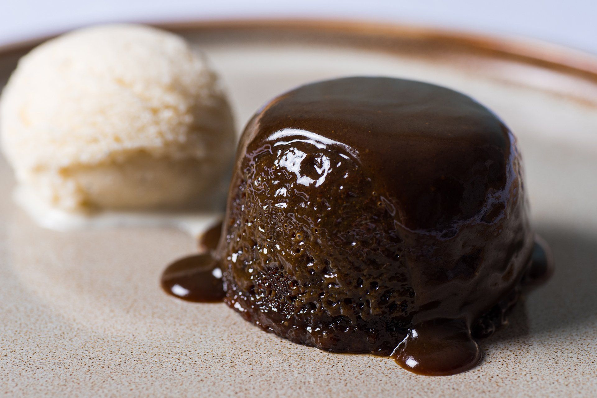 A chocolate pudding with a scoop of ice cream on a plate.
