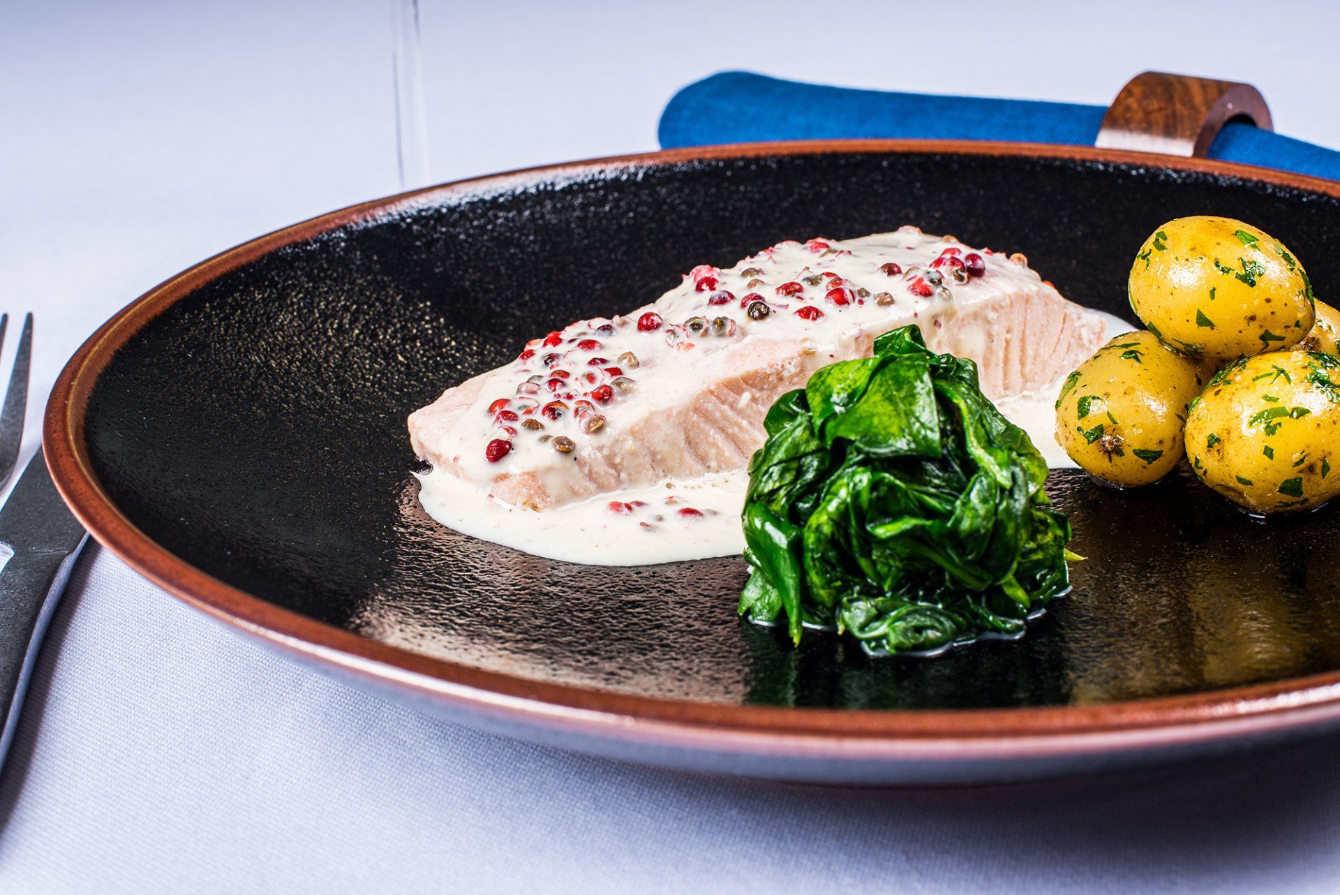 A plate of food with spinach and potatoes on a table.