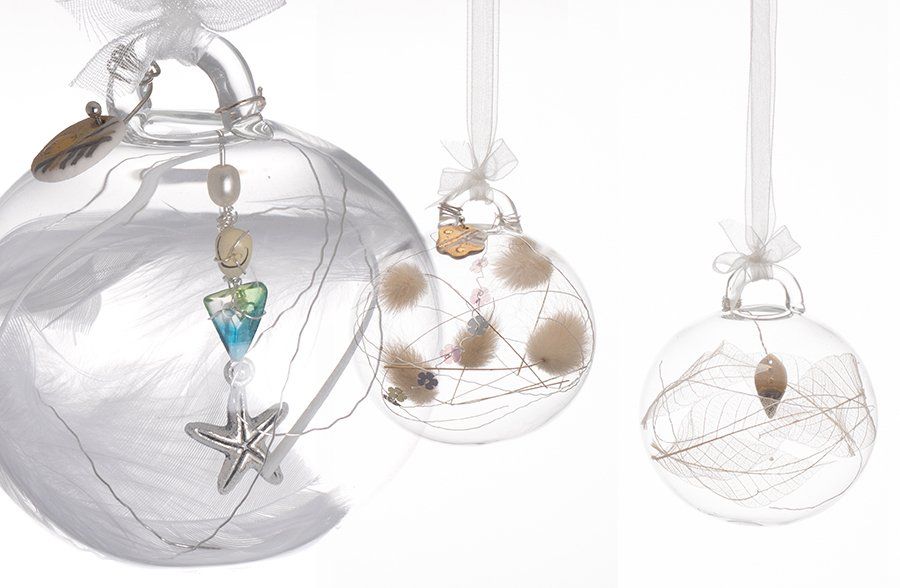 Three clear christmas ornaments with seashells and a starfish hanging from them