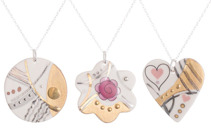 Three necklaces with different designs on them on a white background