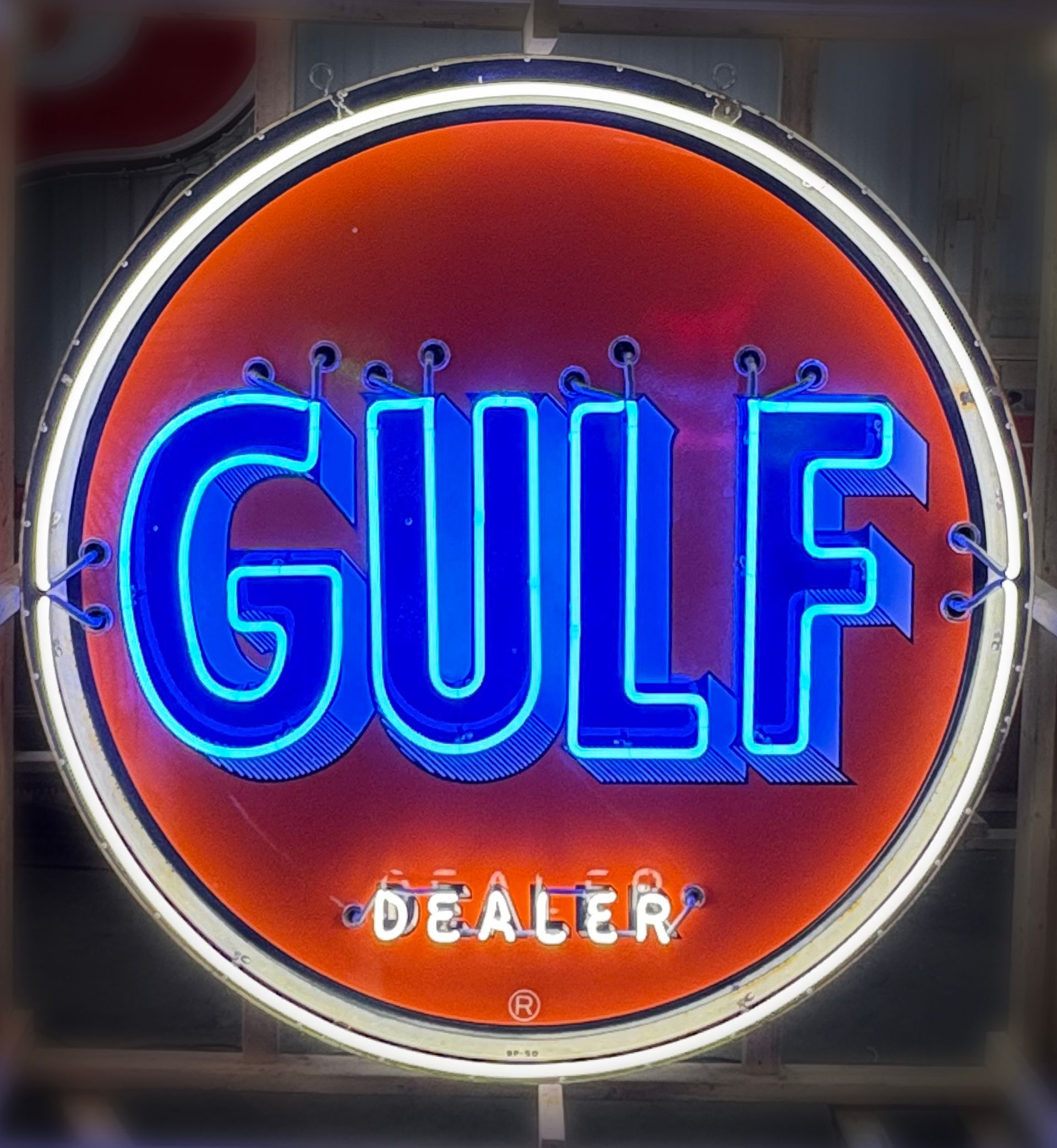 Neon Gulf gas station sign, blue text on orange background, with 