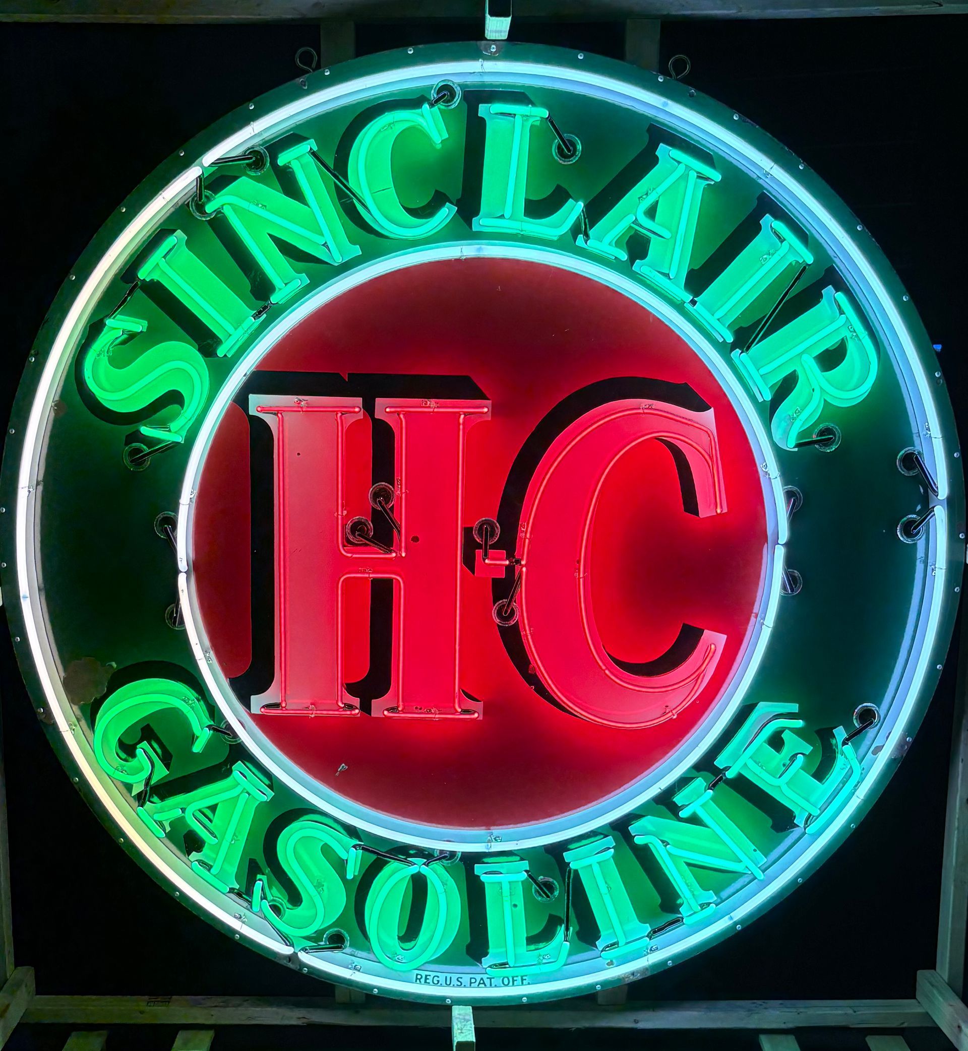 Sinclair gasoline sign with a red HC in the center, green letters on a black background.