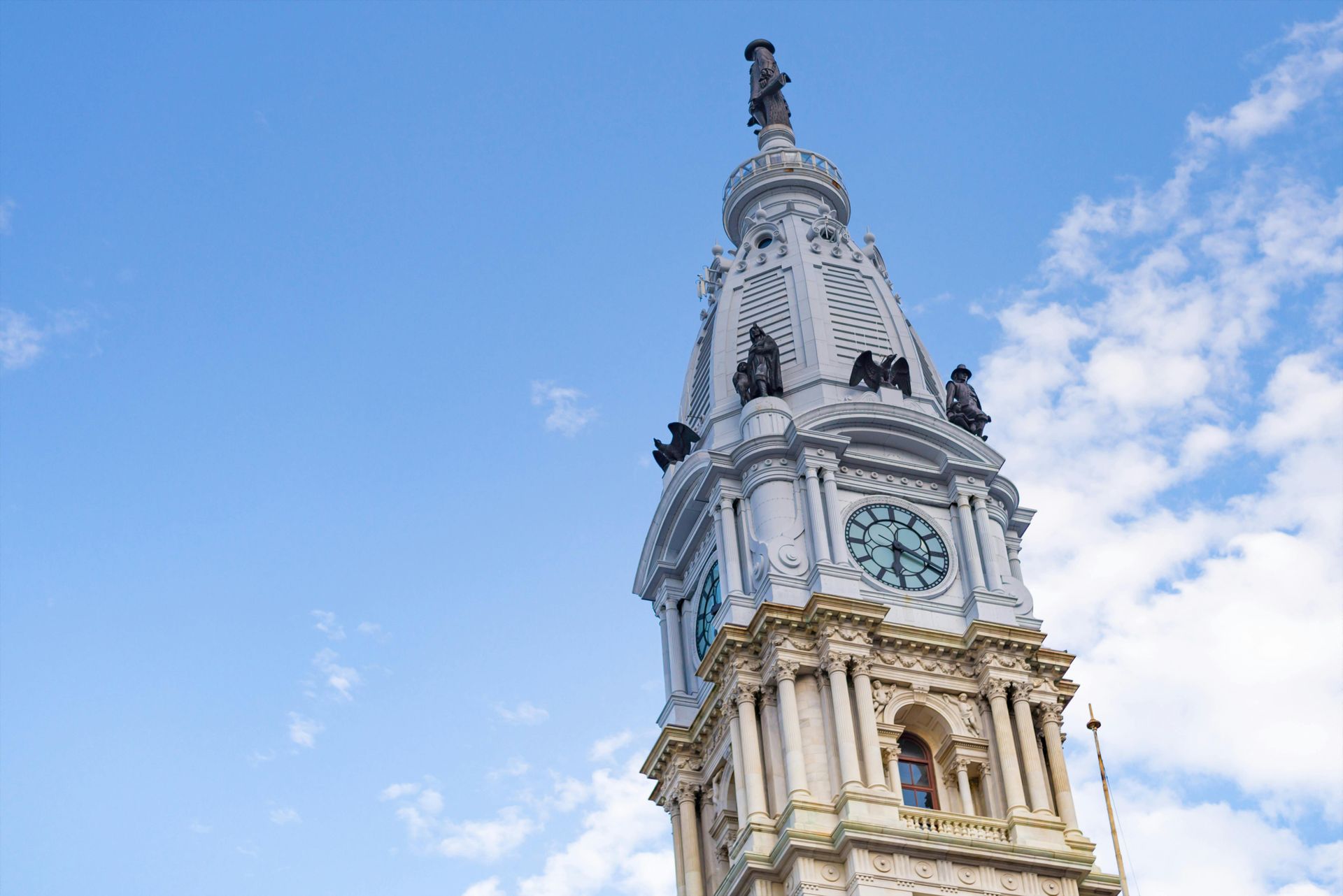 Doctor in lab coat on phone, smiling, at desk with laptop. Office setting, stethoscope.