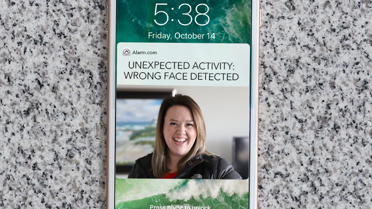A cell phone with a picture of a woman on the lock screen.