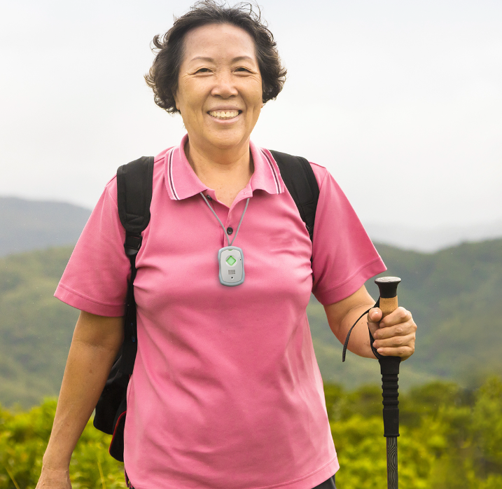 A woman in a pink shirt is holding a hiking pole