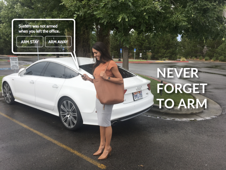 A woman is standing in front of a white car that says never forget to arm