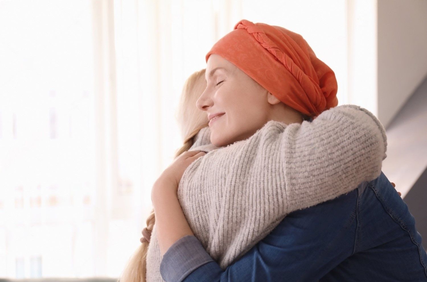 A woman with cancer is hugging another woman.