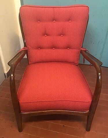 Poltrona con cuscini a righe rosse e struttura in legno.