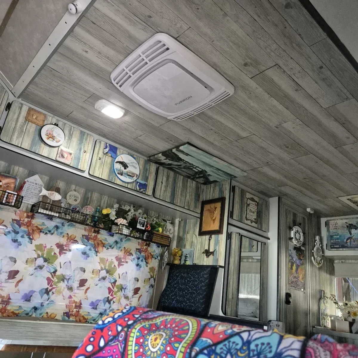Interior of a camper, with an air conditioner, floral decor, and wooden-look paneling — Revive Caravan Repairs in Kippa-Ring, QLD