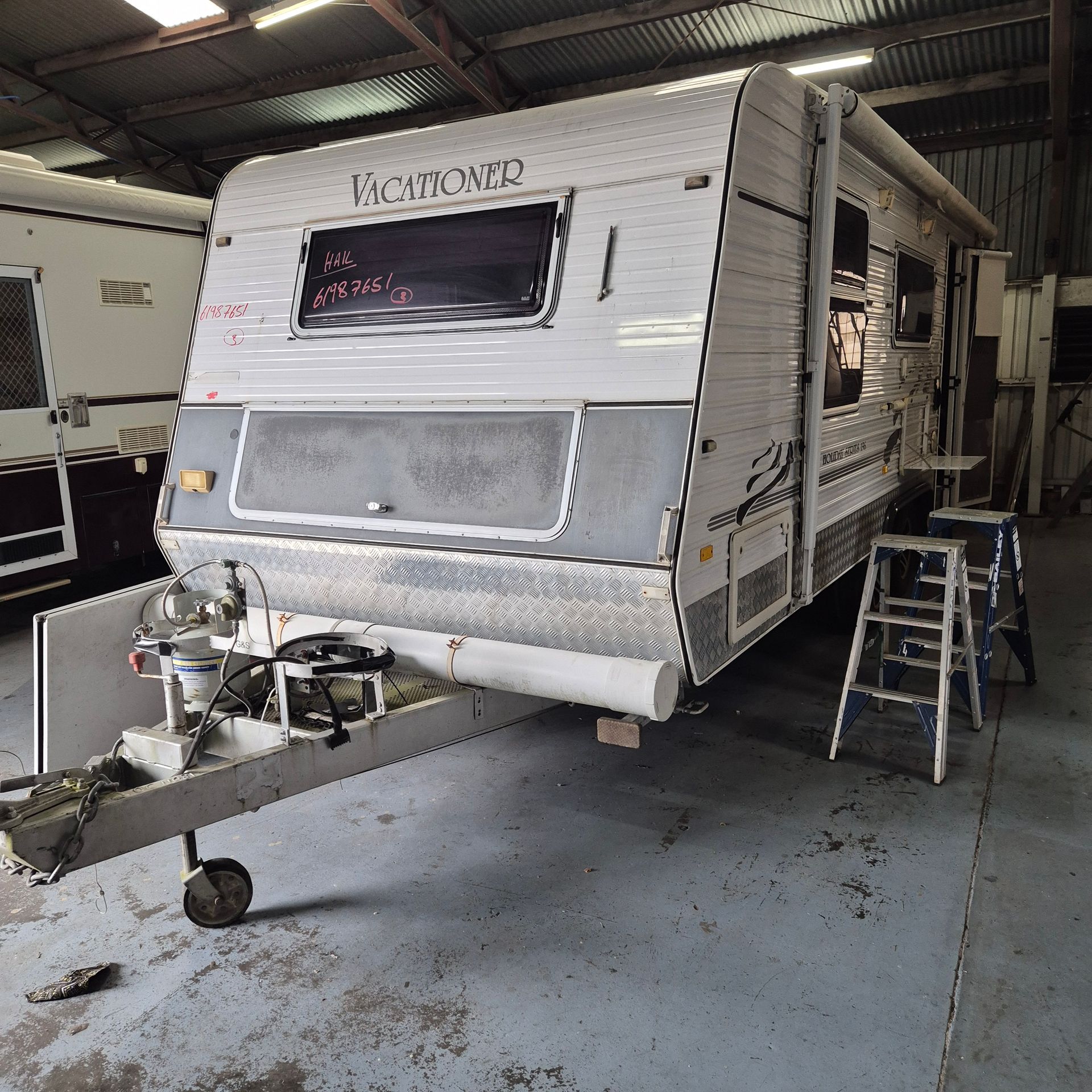 A Caravan Inside a Garage with A Trailer Hitch — Revive Caravan Repairs in Kippa-Ring, QLD