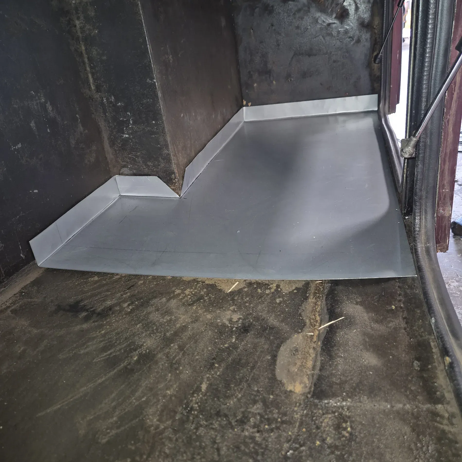 Inside of a dark compartment, a galvanized metal floor and wall flashing are installed — Revive Caravan Repairs in Kippa-Ring, QLD