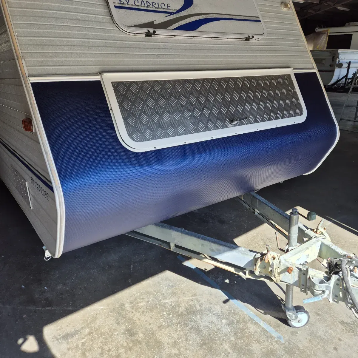 Blue and silver caravan with a diamond-plate accent and trailer hitch — Revive Caravan Repairs in Kippa-Ring, QLD