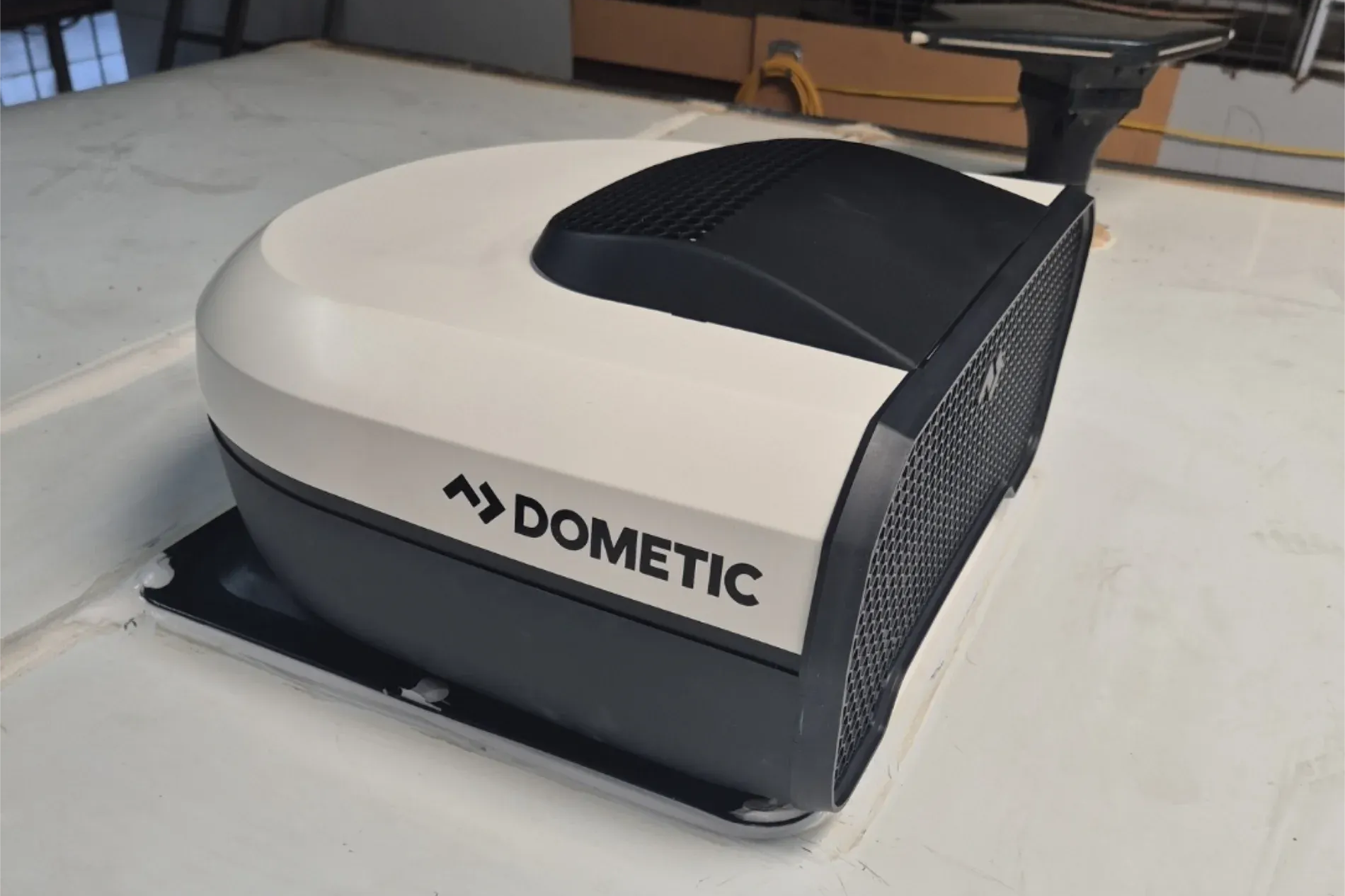 White and black Dometic rooftop air conditioner unit on a white surface — Revive Caravan Repairs in Kippa-Ring, QLD