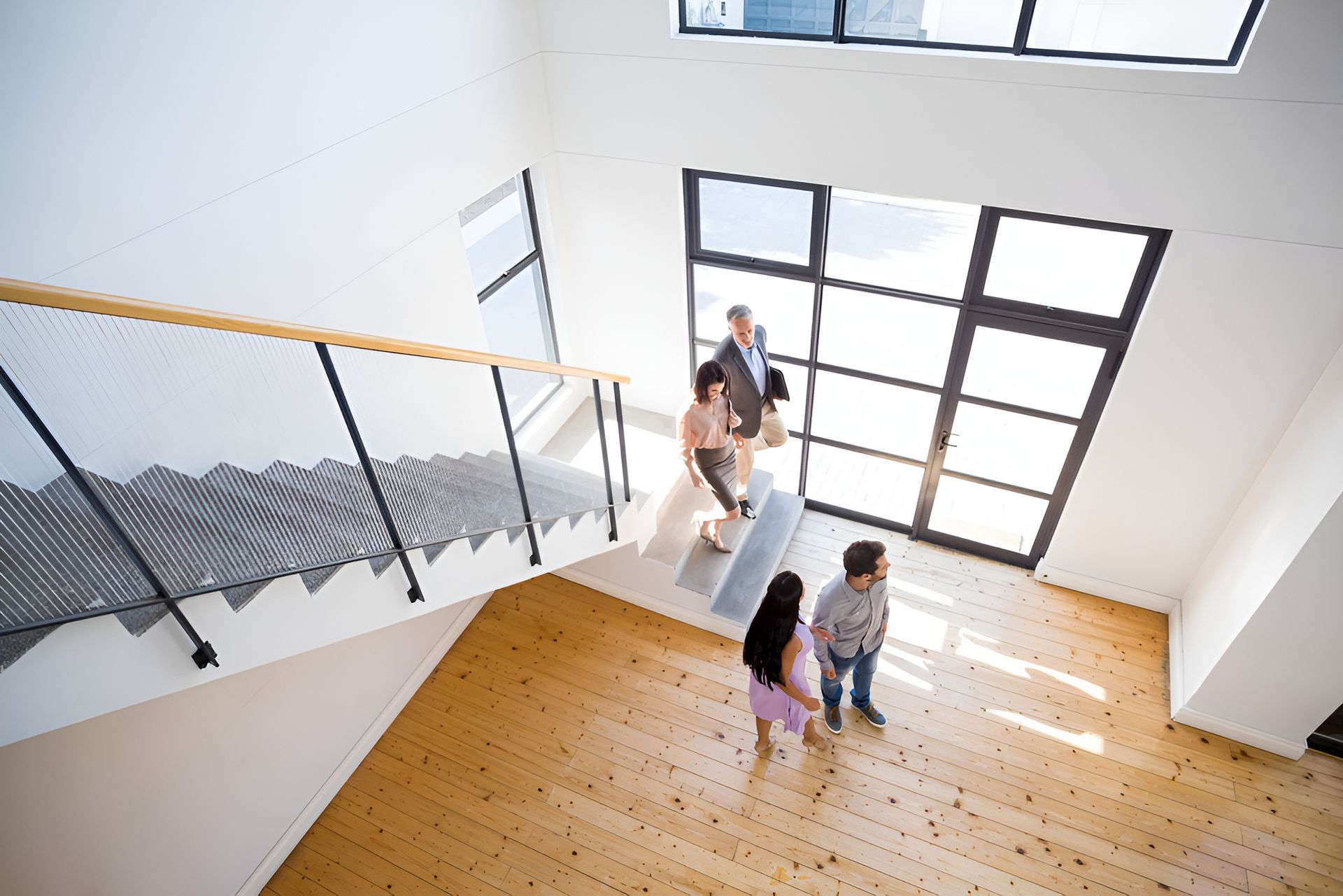 A Group of People Are Standing in a Room With Stairs — Hyde Burchell Buyers Agents In Canberra, ACT