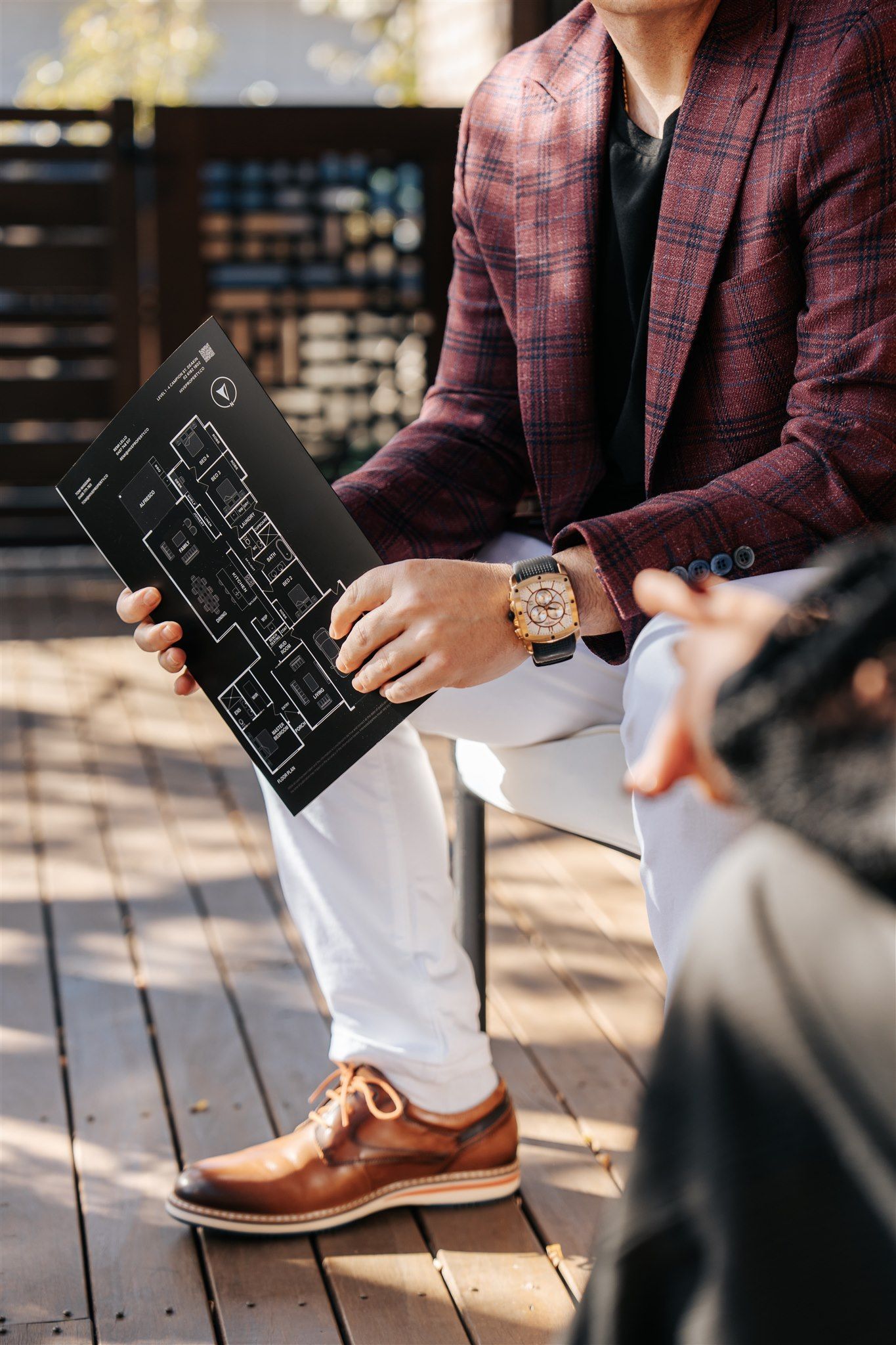 A Man is Sitting at a chair holding a pamphlet — Hyde Burchell Buyers Agents In Canberra, ACT